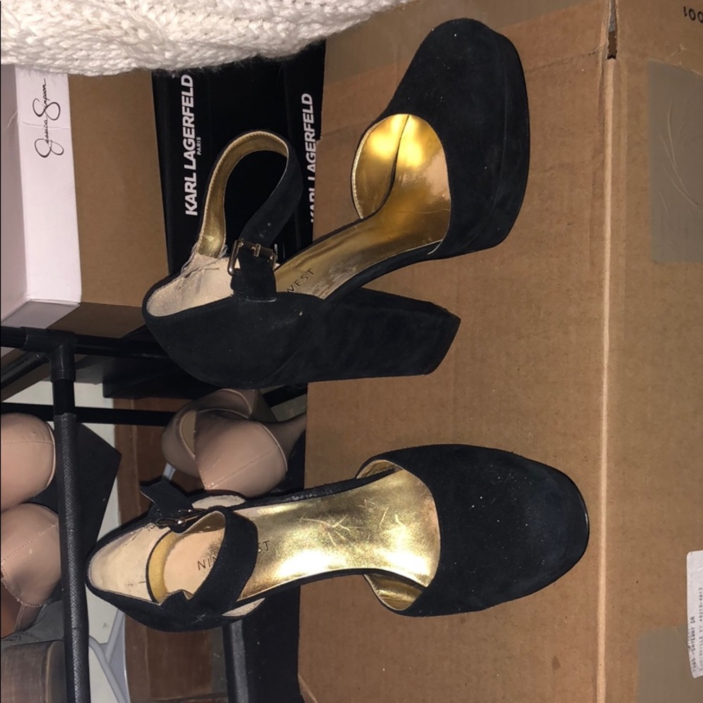A pair of size 7, Nine West black heels w a strap.